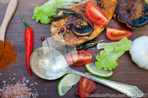 Image of wood fired hoven cooked chicken breast on wood board 