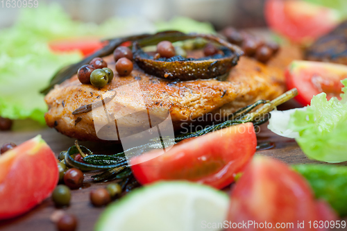 Image of wood fired hoven cooked chicken breast on wood board 