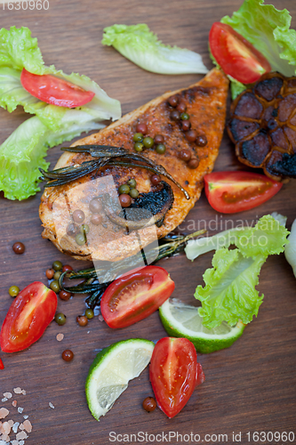 Image of wood fired hoven cooked chicken breast on wood board 