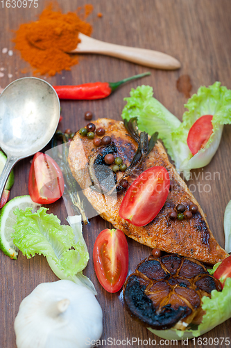 Image of wood fired hoven cooked chicken breast on wood board 