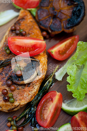 Image of wood fired hoven cooked chicken breast on wood board 