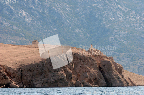Image of A hilltop house and lighthouse above the Adriatic sea near the town of Pag.