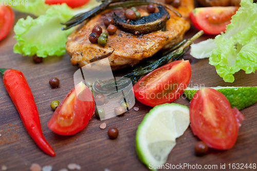 Image of wood fired hoven cooked chicken breast on wood board 