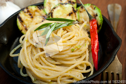 Image of italian spaghetti pasta with zucchini sauce on iron skillet