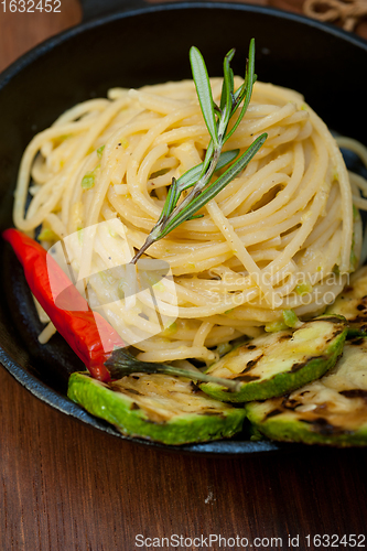 Image of italian spaghetti pasta with zucchini sauce on iron skillet