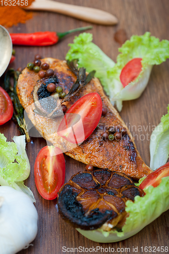 Image of wood fired hoven cooked chicken breast on wood board 