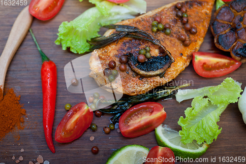 Image of wood fired hoven cooked chicken breast on wood board 