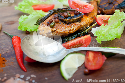 Image of wood fired hoven cooked chicken breast on wood board 