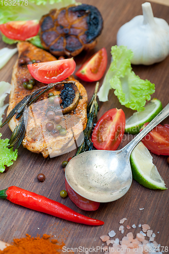 Image of wood fired hoven cooked chicken breast on wood board 