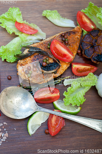 Image of wood fired hoven cooked chicken breast on wood board 