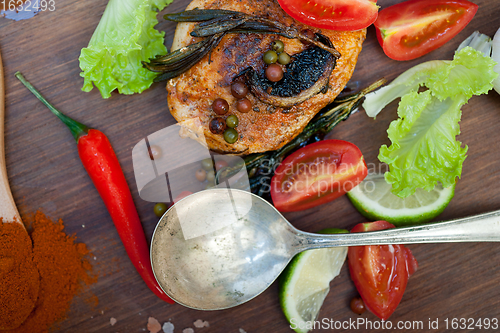 Image of wood fired hoven cooked chicken breast on wood board 