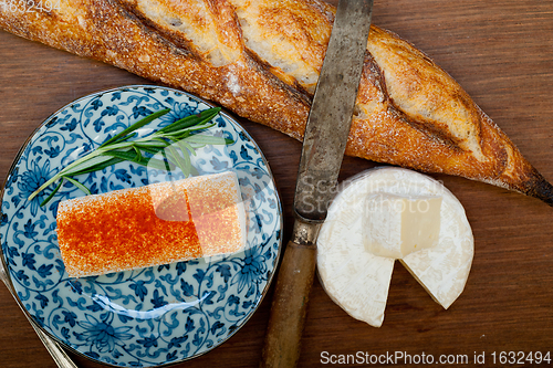 Image of French cheese and fresh  baguette on a wood cutter