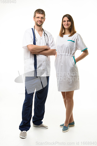 Image of Male doctor and female nurse joyfully looking into the frame, full growth, isolated on white background