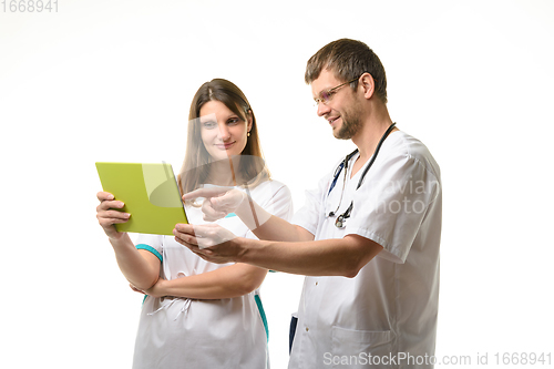 Image of Two doctors discussing the patient\'s tests while looking at the tablet computer screen