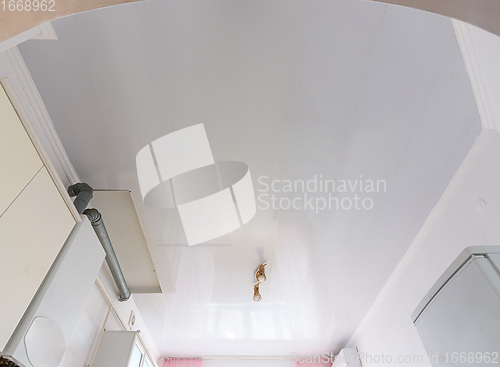 Image of White ceiling from plastic panels in the interior of the kitchen