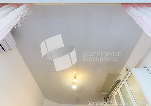 Image of A budget ceiling made of white plastic panels in a spacious kitchen