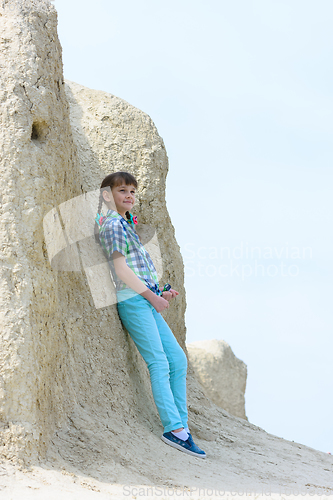 Image of Ten year old girl pressed her back against a rock