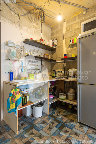 Image of A temporary kitchen made of planks and shelves in a renovated room