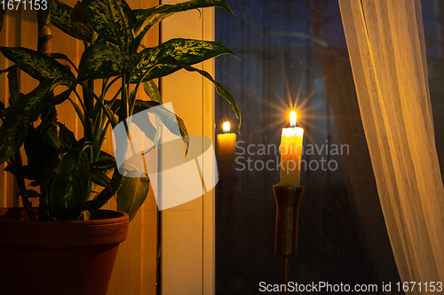 Image of A lonely candle stands by the window in the evening as a token of memory of those who died in wars