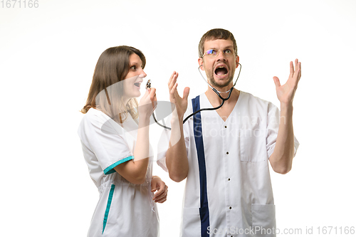 Image of Girl doctor screams into the head of the phonendoscope worn by the doctor, the doctor screams from a loud sound