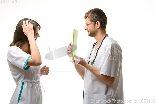 Image of The intern is thinking about the question of the tablet computer shown by the doctor