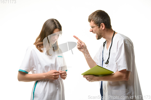 Image of The doctor yells at the intern for an error in the patient\'s record