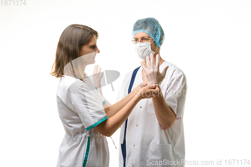 Image of A nurse puts sterile medical gloves on the surgeon\'s hands