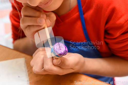 Image of Paints a figurine of salt dough for a girl in class