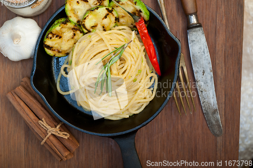 Image of italian spaghetti pasta with zucchini sauce on iron skillet