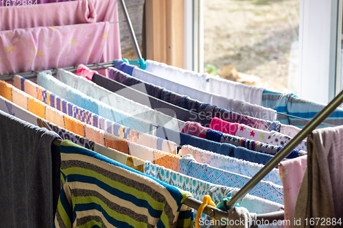 Image of The washed clean linen is dried in a dryer near the window