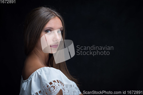 Image of Portrait of a beautiful girl turned around and looked into the frame