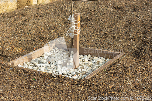 Image of Wooden hole covered with decorative fine gravel for a fruit tree seedling