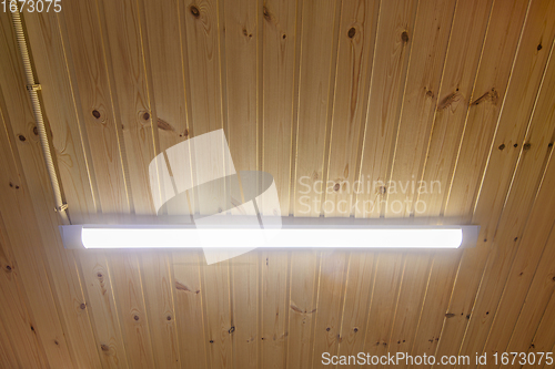 Image of Long LED lamp on wood paneling ceiling