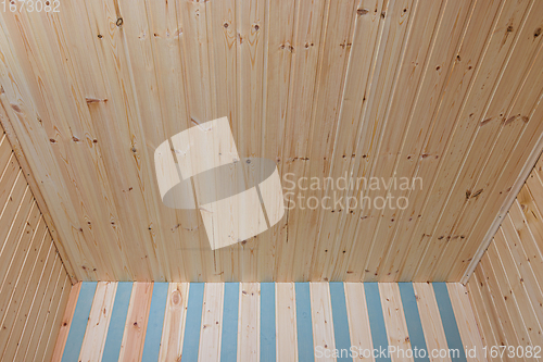 Image of Part of the ceiling and walls finished with wooden lining in a small country room