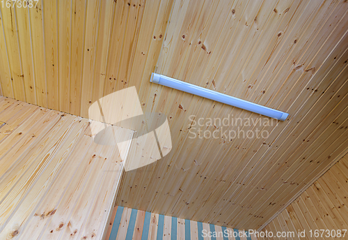Image of View of a ceiling made of wood clapboard with fixed length LED daylight lamp