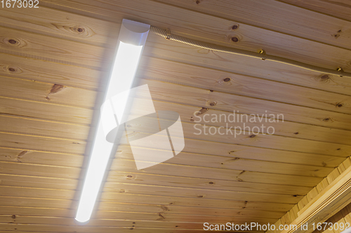 Image of Included daylight lamp on wood paneling ceiling