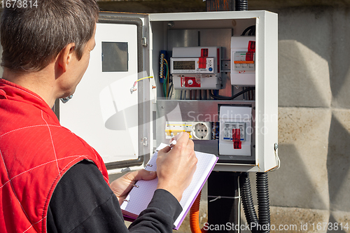 Image of An electrician takes control readings of electricity meters