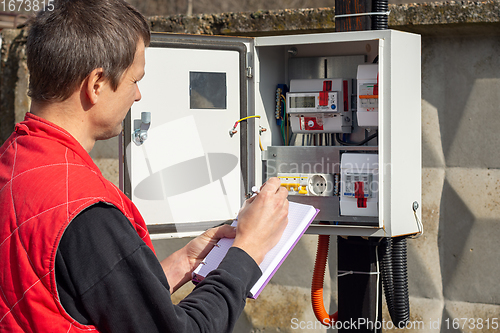 Image of An energy sales worker takes readings of electricity meters