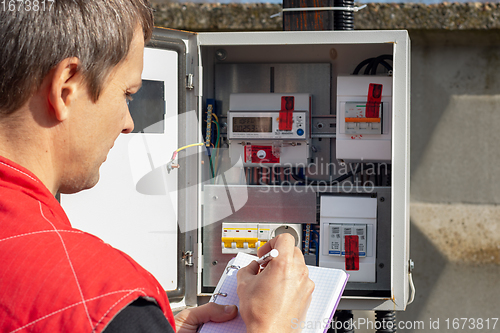 Image of A resident of a country house records the monthly readings of the electricity meter