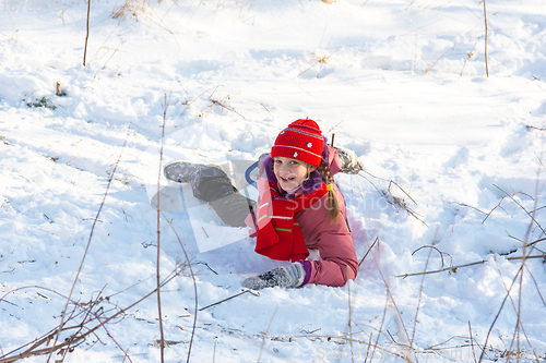 Image of The girl rolled down the hill and happily looked into the frame