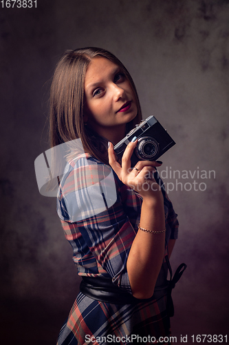 Image of Girl photographer with retro camera, studio photography on gray background