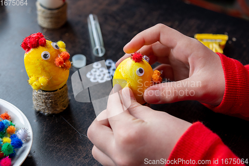 Image of Children\'s hands make a craft from an egg for the Easter holiday