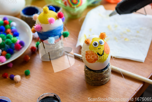 Image of Painted easter egg with glued eyes stands on the table