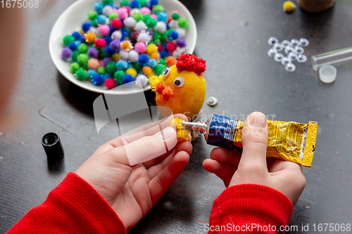 Image of Child\'s hands make a chicken-shaped egg shell craft