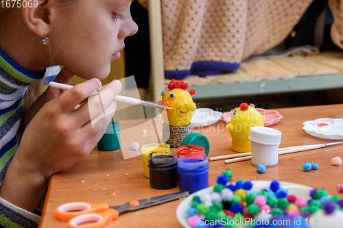 Image of The girl paints crafts from eggs for the Easter holiday