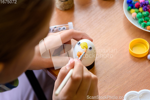 Image of Close-up of hands of a child painting Easter eggs