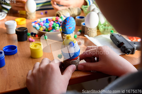 Image of The child\'s hands are carefully holding toys from eggs for the Easter holiday