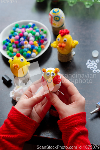 Image of Child\'s hands hold a painted egg as a gift to celebrate easter