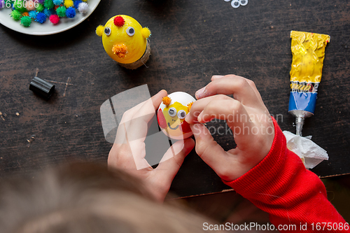 Image of Girl making figurines from eggs, top view