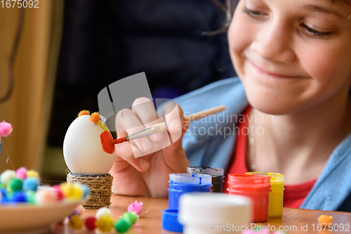 Image of Happy girl painting easter eggs for the holiday
